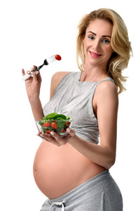 美丽的怀孕妇女举行有机沙拉。孕产妇期望健康饮食