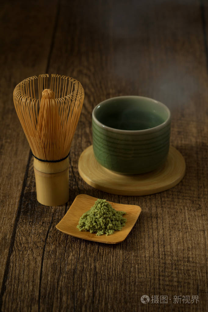 绿茶旳日本酒传统与木背景和热的烟从茶