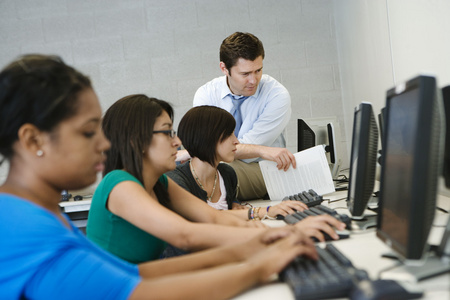 教师帮助学生在计算机实验室
