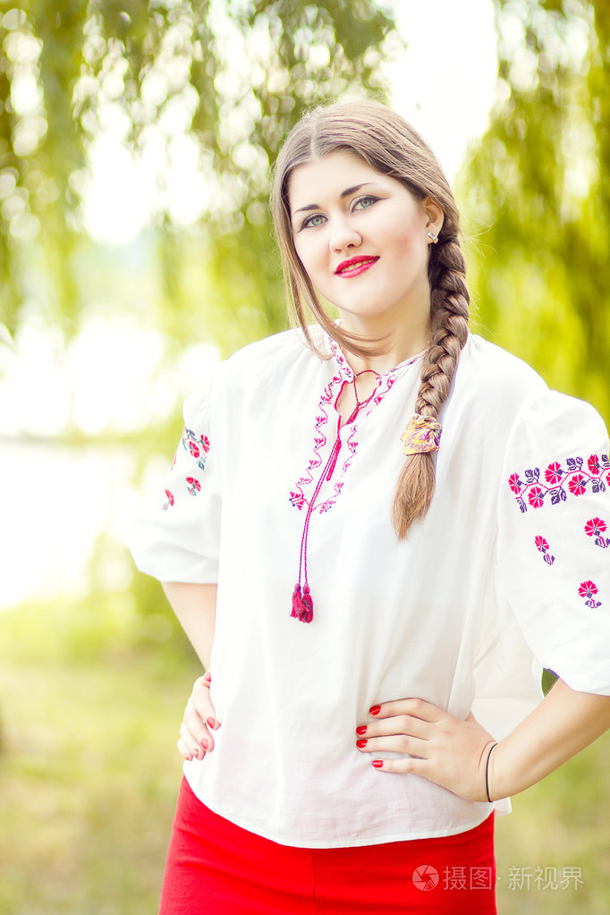 户外时尚棕色的头发的女人肖像绣乌克兰民族服装.