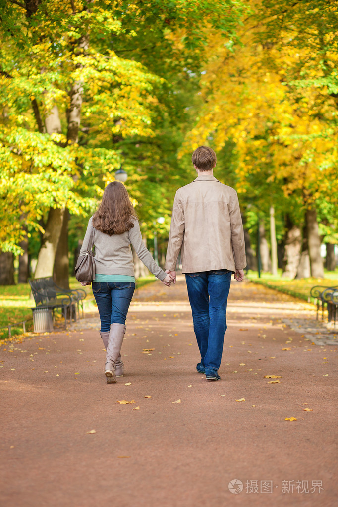 在秋天的一天在公园里一起散步的夫妇