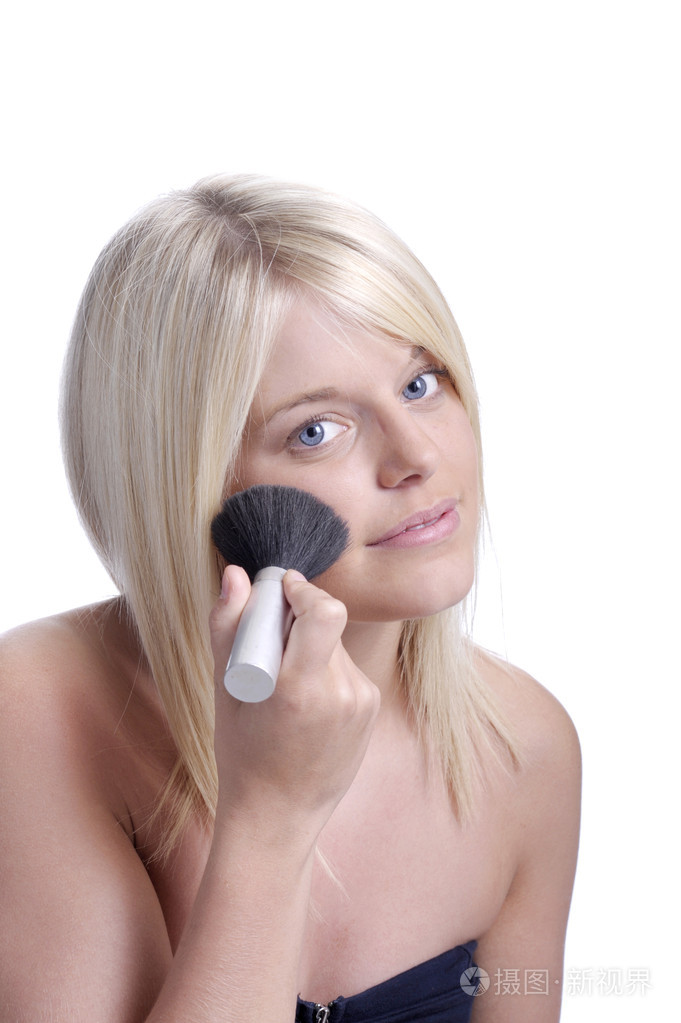 年轻的金发女人应用脸红
