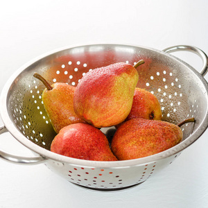 成熟的红梨漏勺白色背景。夏季水果, 收获