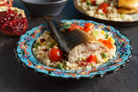 摩洛哥食品与蒸粗粉, 熏鱼和蔬菜在传统的盘子