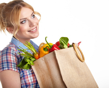 女人抱着装满了食品杂货购物袋