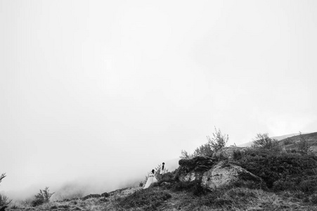幸福新婚夫妇在山中漫步的黑白照片