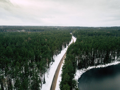 在冬天的树林之间的道路无人驾驶摄影