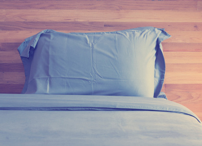 蓝色的枕头和木板墙上的老式卧室