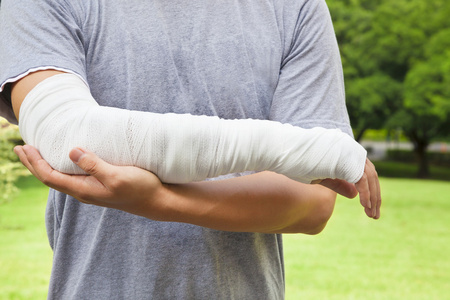 绷带手臂与公园背景的特写照片