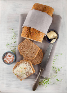 新鲜 wholegrain 面包在白色木制厨房桌用盐和黄油可以作为背景