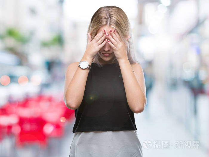 年轻的金发女人在孤立的背景下, 悲伤的表情覆盖脸与手, 而哭.