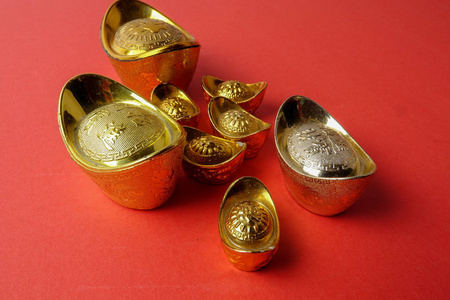 金锭为农历新年喜庆装饰品在红色背景。汉字意味着运气, 财富和繁荣, 如图所示