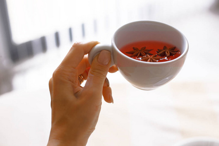 一个女孩早上带了一杯茶, 手里拿着一杯茶.照片