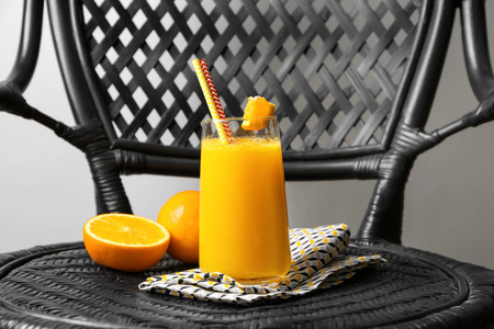 玻璃杯鲜汁与椅上柑橘片水果图片