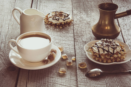 白杯咖啡配牛奶, 白牛奶壶, 红糖和自制的华夫饼, 上面装饰着奶油。美味早餐