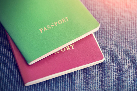 蓝色纺织品背景下的两张红色和绿色护照
