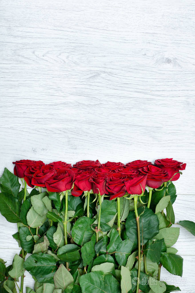 花束猩红玫瑰在一个轻的木质背景特写