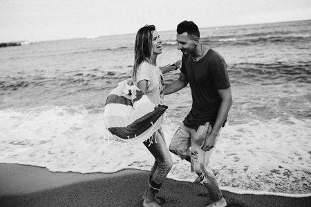 幸福的夫妇在海滩上散步的爱