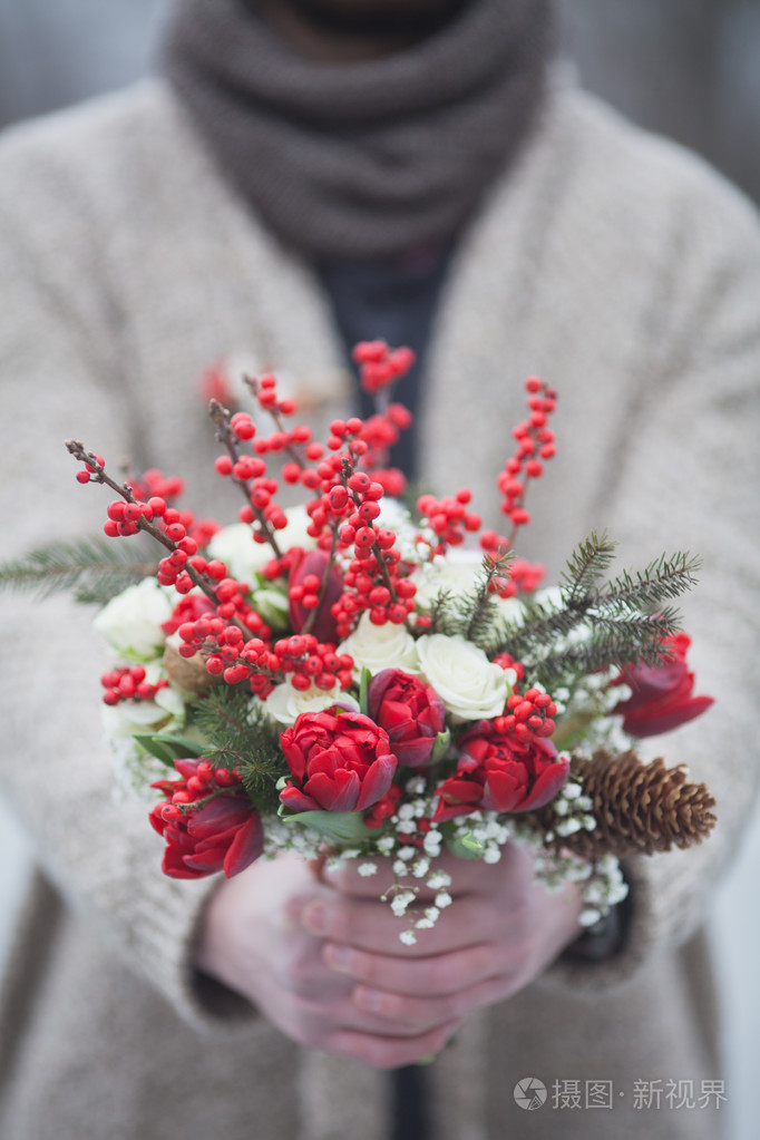 男人在公园在冬天用一束红色的鲜花