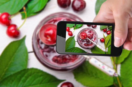 手中的照片樱桃果酱，智能手机