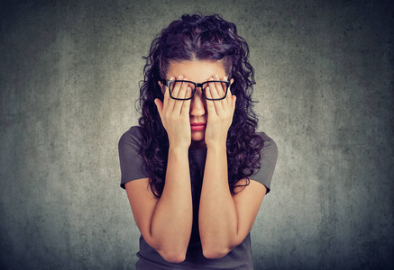 戴眼镜的年轻女子双手捂着眼睛图片