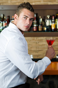 美丽的男人喝红马提尼酒图片