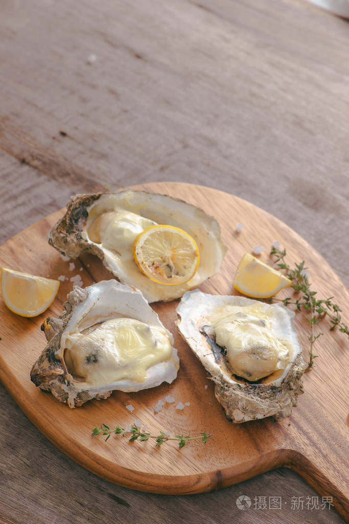 美味的新鲜牡蛎与切片柠檬在切割板.增强望的壮阳食品