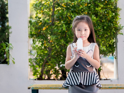亚洲可爱小女孩的肖像拿瓶牛奶图片