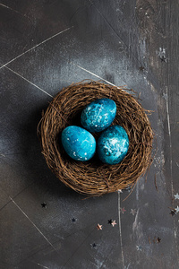 复活节彩蛋在巢画在蓝色在黑暗的背景下用手