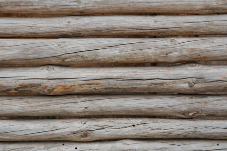 天然光线下的木栅栏。背景与水平旧未漆木原木