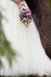 蓝色和白色婚纱的新娘手中的花束