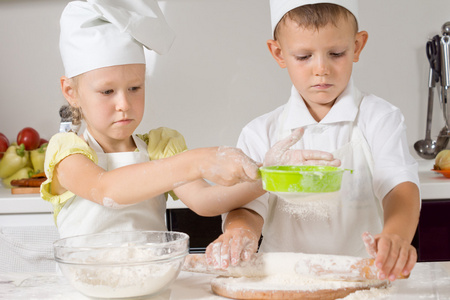 小男孩和女孩在厨房里烤