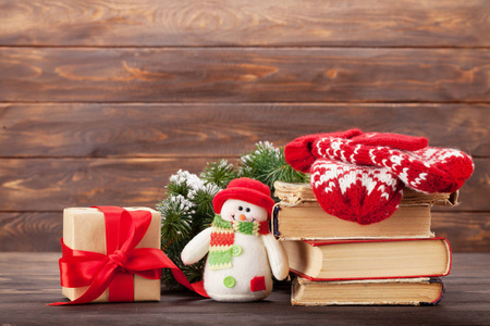 圣诞贺卡与礼品盒, 雪人玩具和手套在木墙前。带给你问候的空间