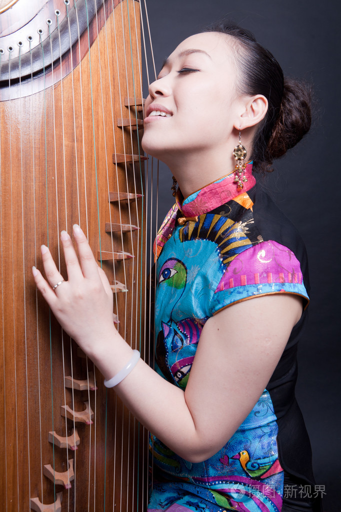 年轻妇女和中国古筝演奏