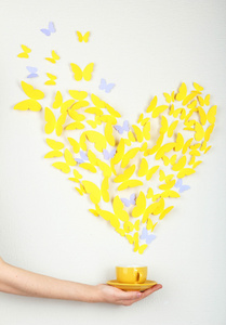 在窗体的心飞出杯中黄色的纸蝴蝶