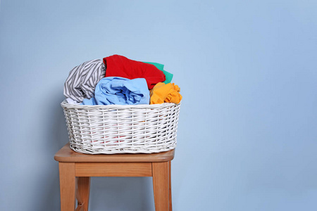 洗衣篮与脏衣服在凳子上对颜色背景
