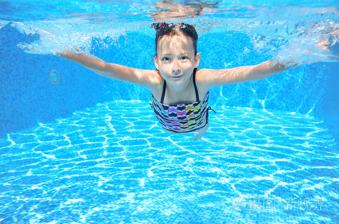 快乐积极的水下孩子在游泳池里游泳