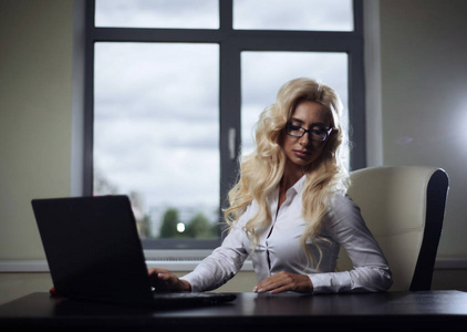 老板的办公桌有吸引力的老板女孩坐在办公桌在办公室和工作与笔记本