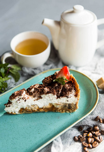 意大利甜点提拉米苏用茶壶和一杯茶照片