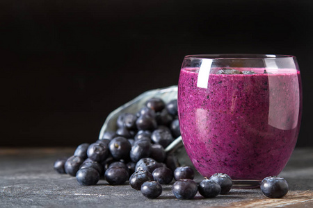 玻璃杯里的新鲜多汁蓝莓果汁。简单的背景