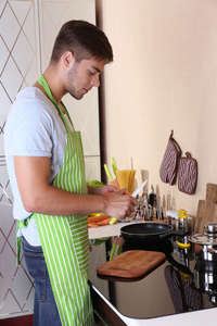 英俊的男人，在家里的厨房里做饭