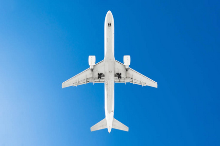 乘客飞机。从下面看, 白色的剪影对蓝天