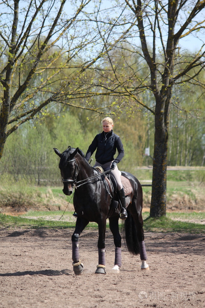 金发女人骑乘黑色马