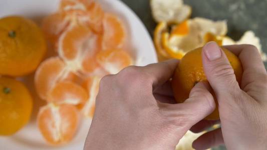 女手剥去了柑橘的果皮, 在碗里堆满了国语片。
