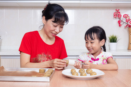 亚洲华人母女在家厨房做月饼