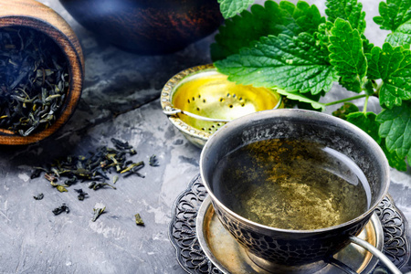 新鲜的天然绿梅丽莎草药茶在杯子里。放松健康饮料