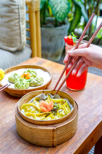 芦笋豆腐饺子特写。食品棒和中国食品。在一张花和手的木桌上。宏观。具有复制空间的顶部视图