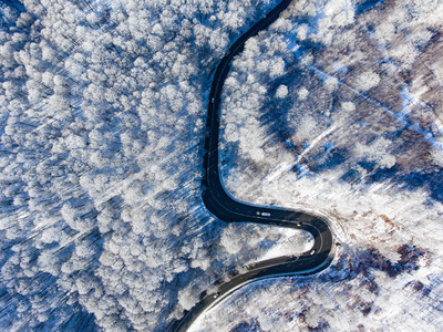 冬季道路上的汽车雪覆盖树木鸟瞰图