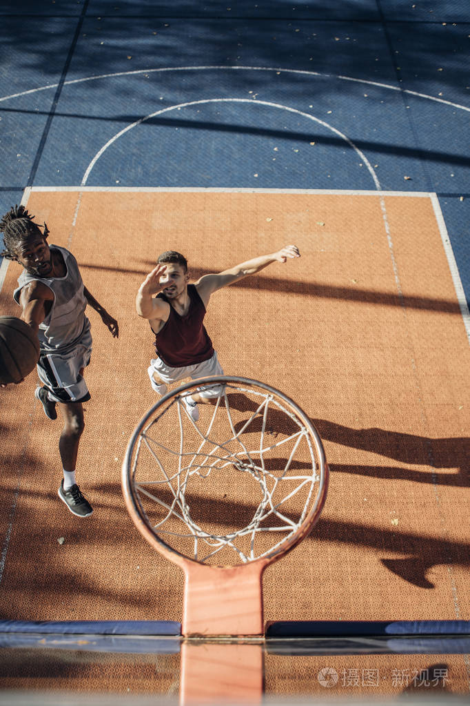 从上面的两个年轻球员在户外球场打篮球的照片