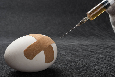 用医用注射器注射到一个鸡蛋与膏药关闭